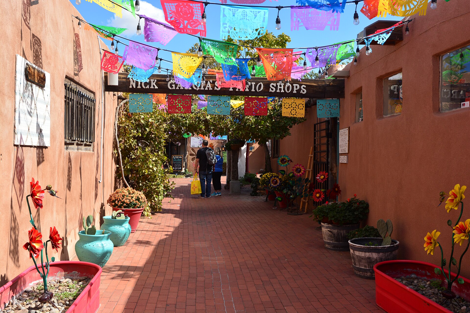 Adobe storefronts and a shaded portal on the Old Town plaza